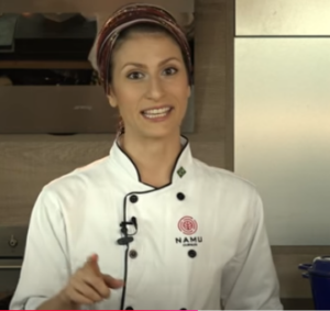 mulher de camisa branca sorrindo e falando sobre curso marmitas saudaveis e fazer renda extra